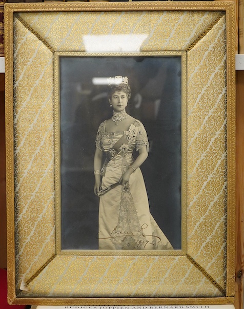 A framed photograph of Queen Mary, signed by the Queen across the bottom of the image and dated 1917, contained within a gilt padded mount and leather frame, overall dimensions 44 x 33cm